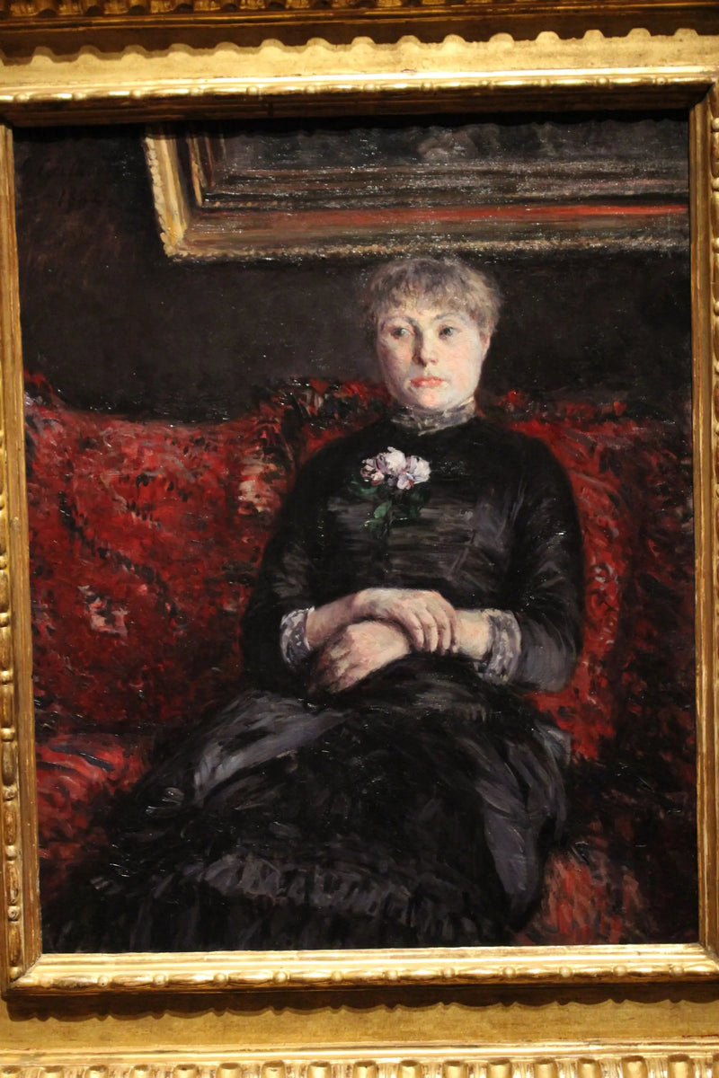 Nainen istuu punakukkaisella sohvallä - Gustave Caillebotte